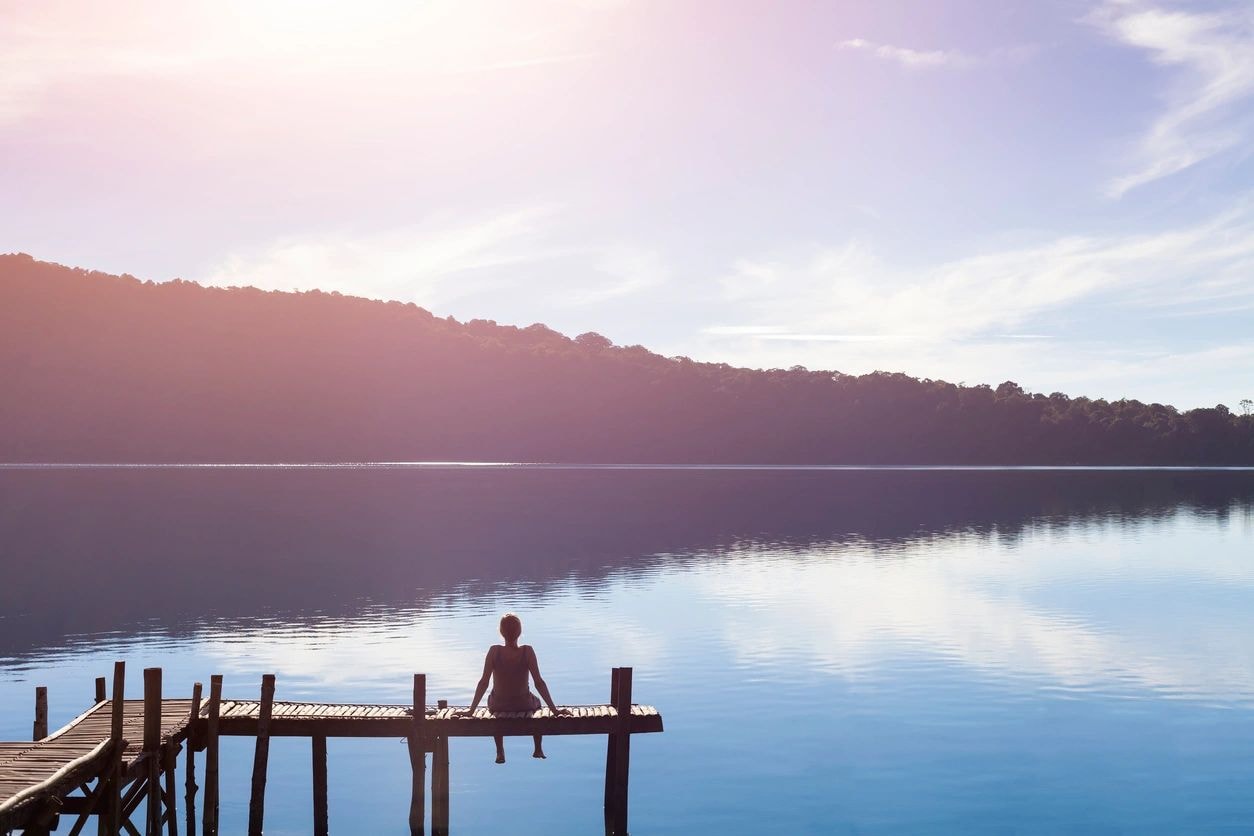 Solitary figure on a dock at dawn — contemplation and prayer